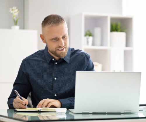 Mann schreibt mit beim Online Führungsseminar