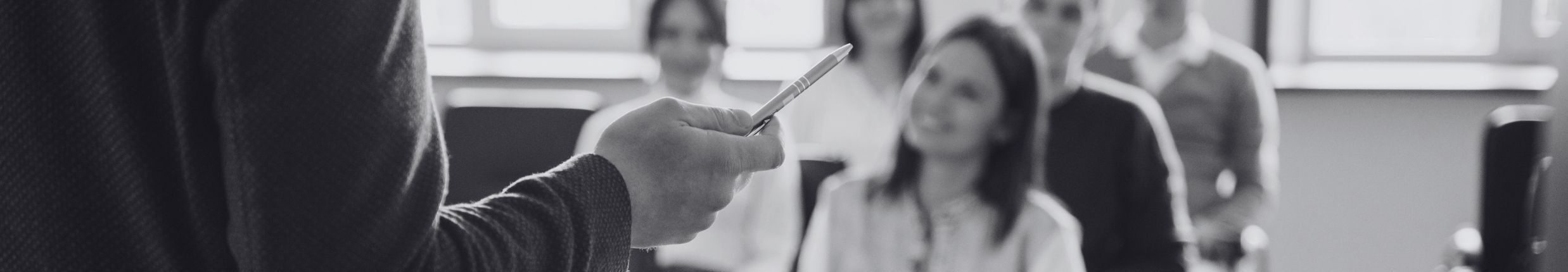 Speaker hält Stift in die Luft, Publikum lacht