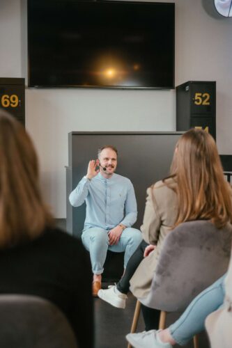 Speaker Markus Lennackers sitzt auf Podium und hält Keynote