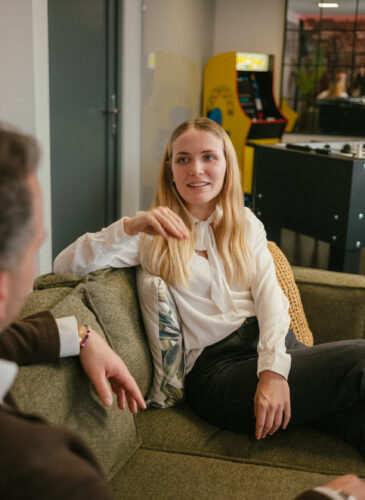 Frau sitzt auf Sofa und spricht mit einem Mann