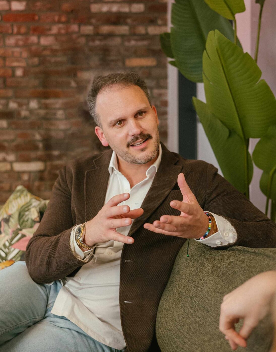 Coach Markus Lennackers sitzt auf Sofa und redet