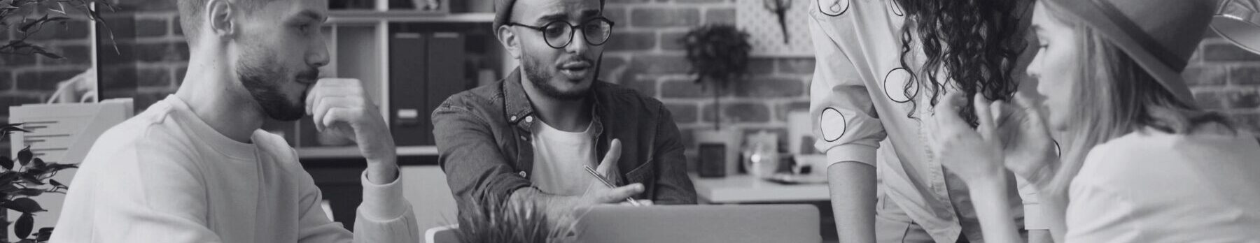 Team sitzt vor Laptop und diskutiert