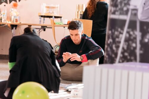 Teilnehmer klebt etwas auf beim Visionboard Workshop