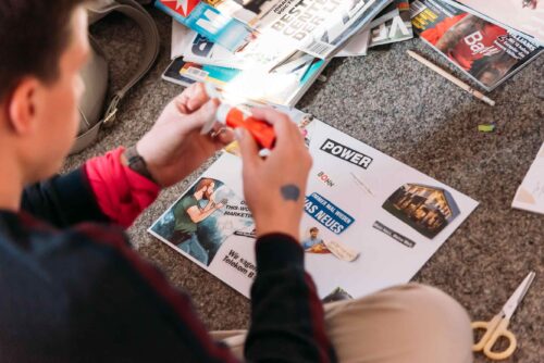 Teilnehmer klebt etwas auf sein Visionboard beim Workshop