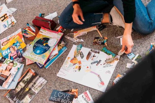 Teilnehmerin klebt etwas auf ihr Visionboard beim Workshop